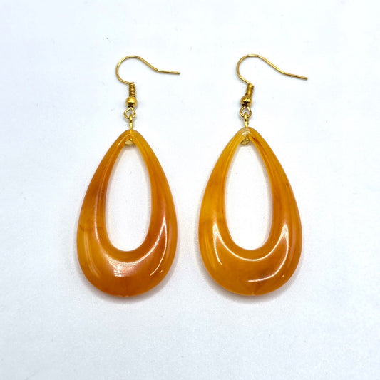 Pair of orange teardrop earrings on a white background