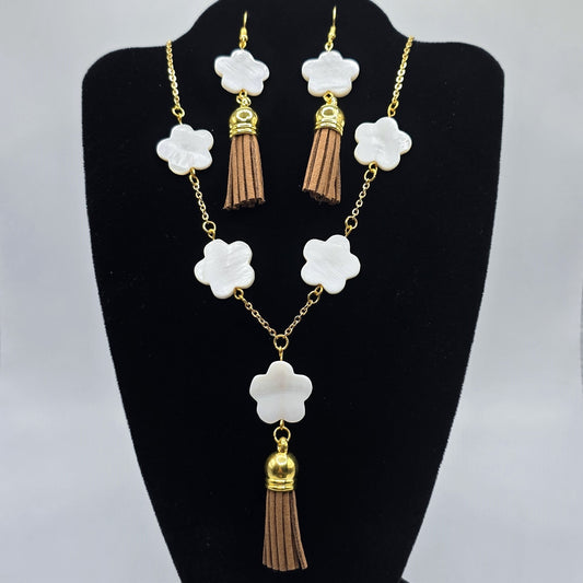 Jewelry set with necklace and earrings on a black stand against a gray background