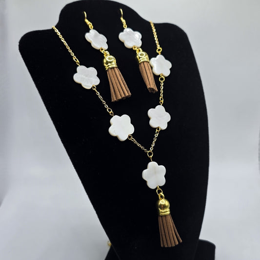 Jewelry set with necklace and earrings on a black stand against a white background