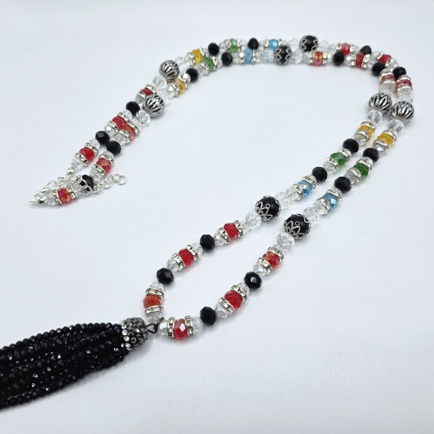 Multicolor beaded necklace with a black tassel on a white background