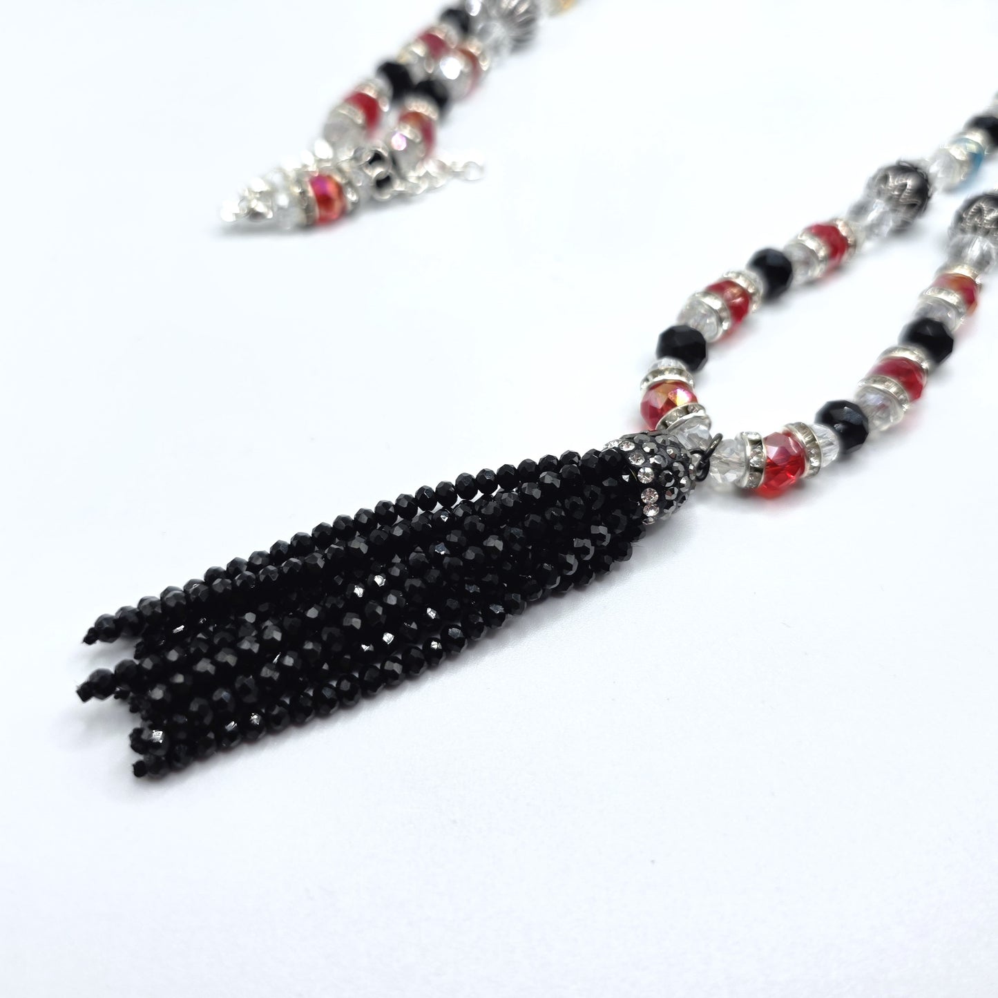 Beaded necklace with a black tassel on a white background