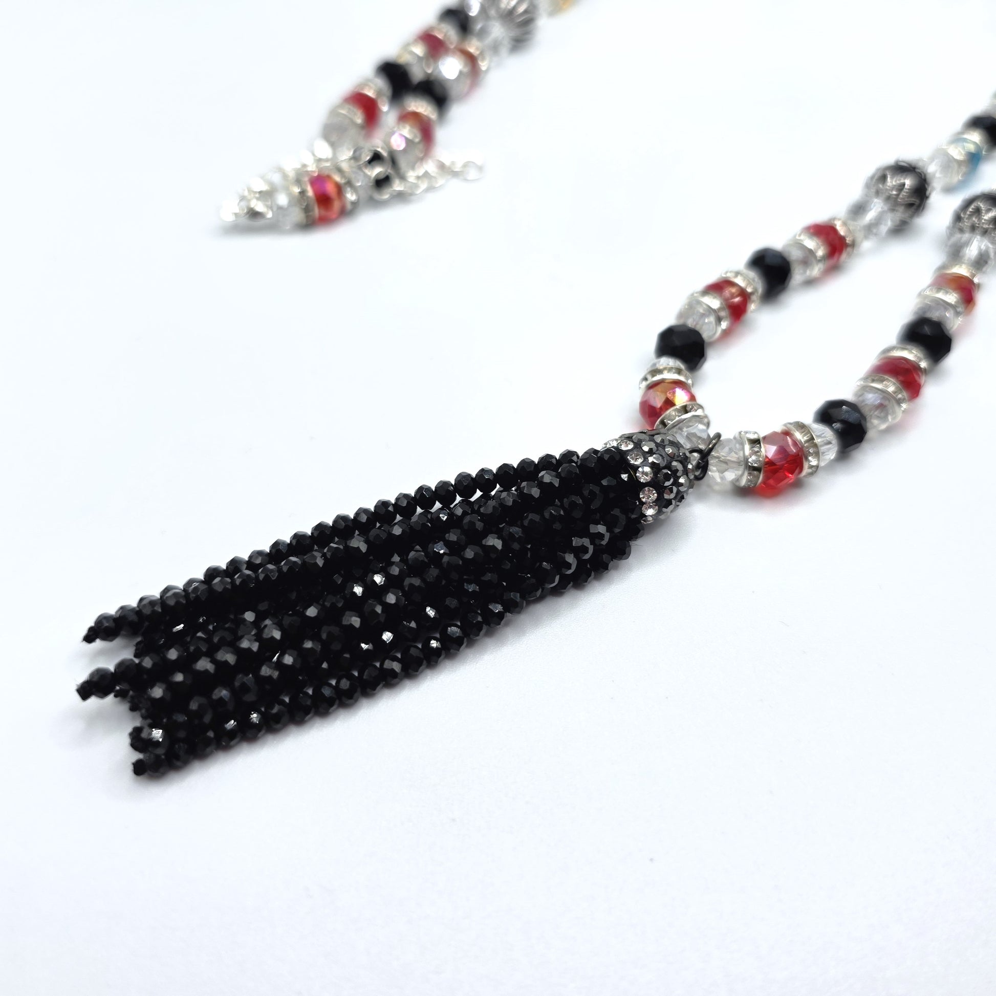Beaded necklace with a black tassel on a white background