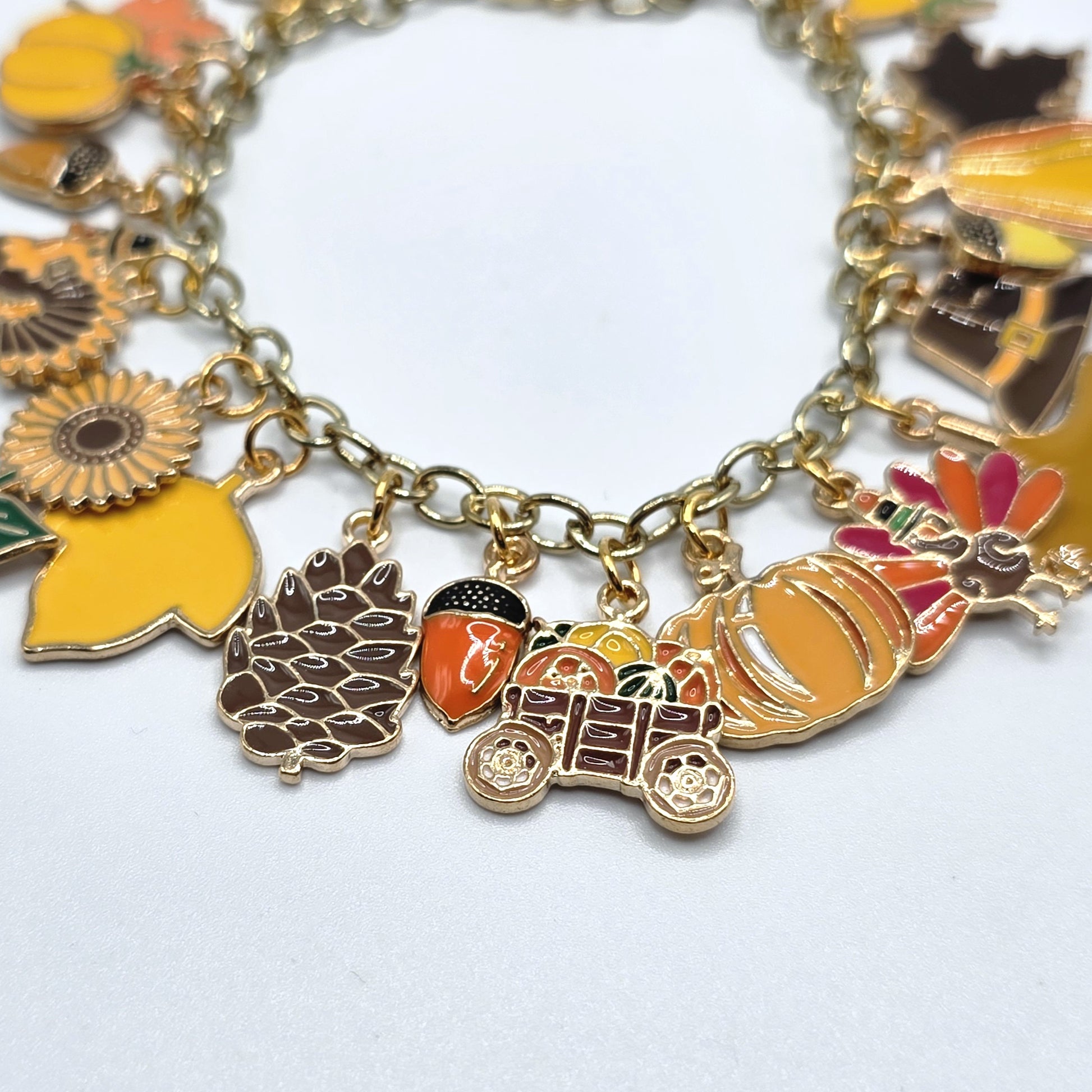 Bracelet with various charms including a pumpkin, wagon, and leaves on a white background