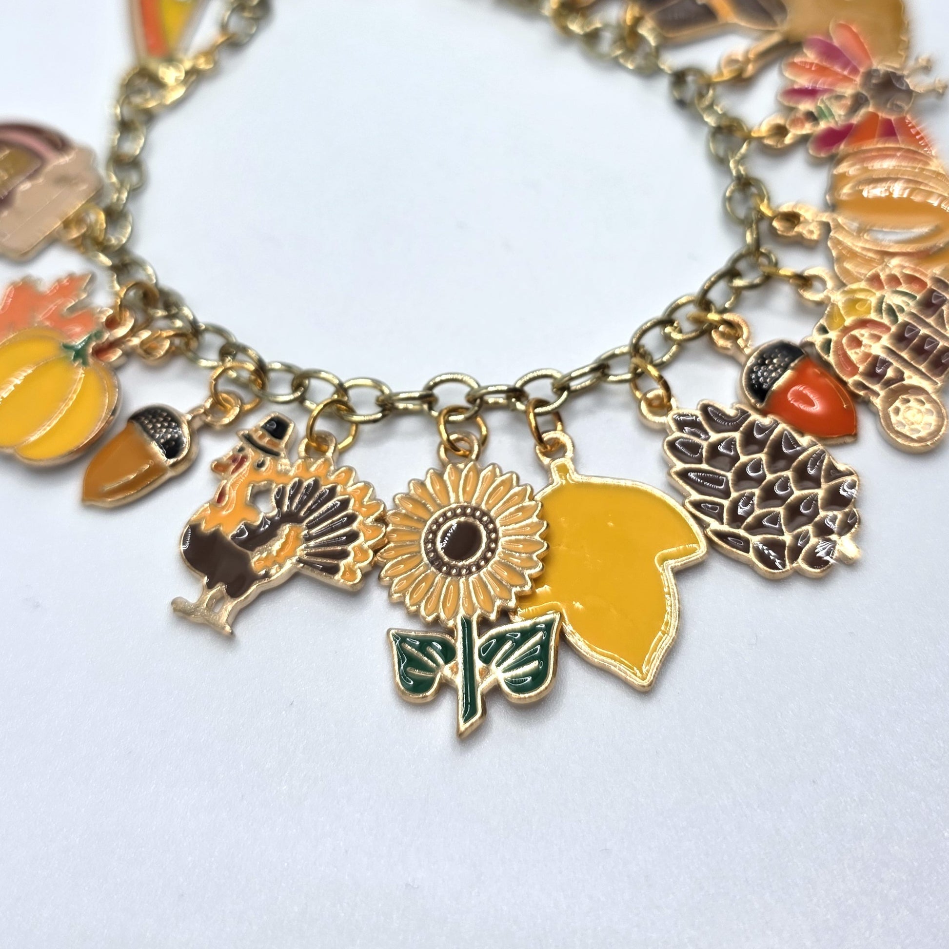 Gold charm bracelet with various charms on a white background