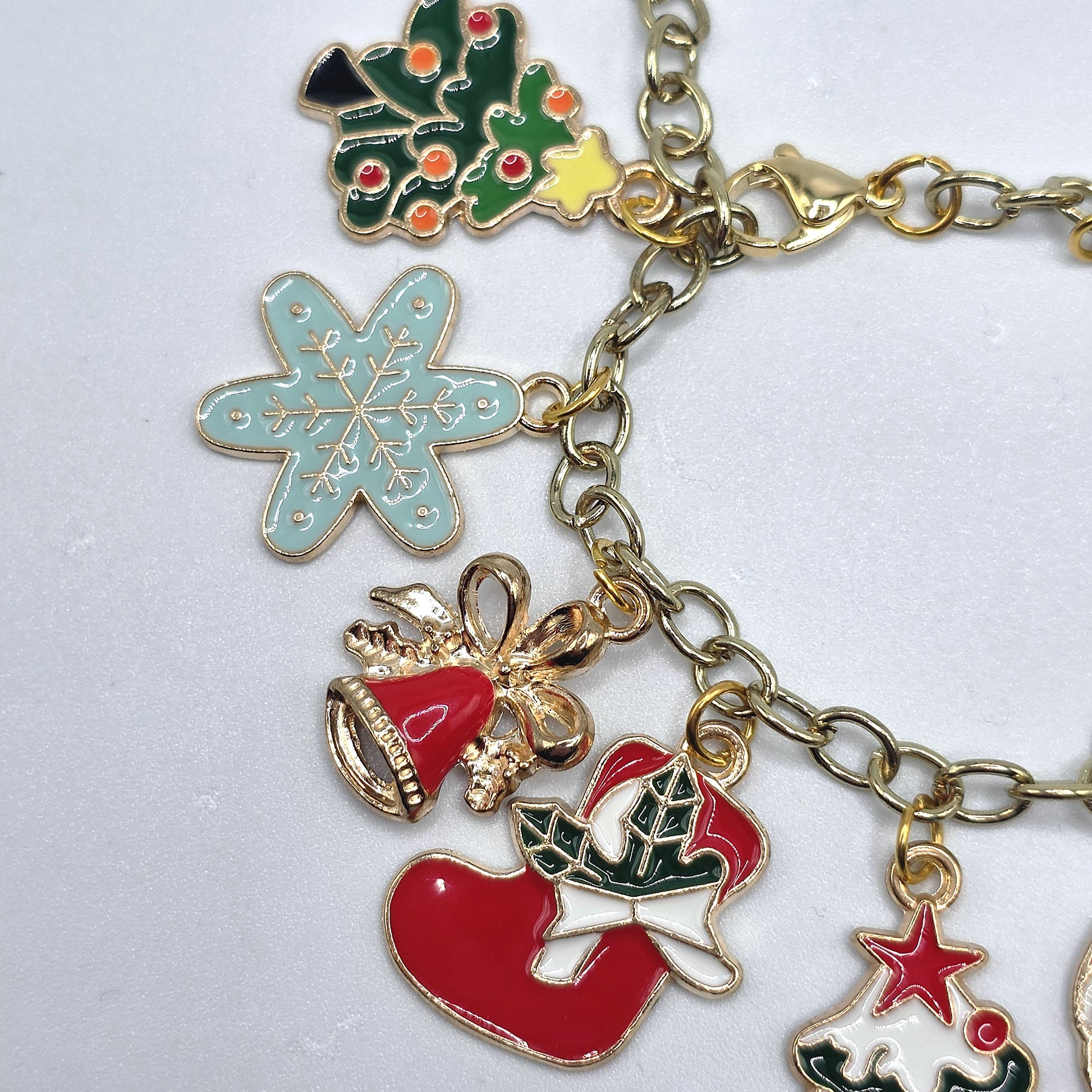 Gold charm bracelet with various colorful charms on a white background