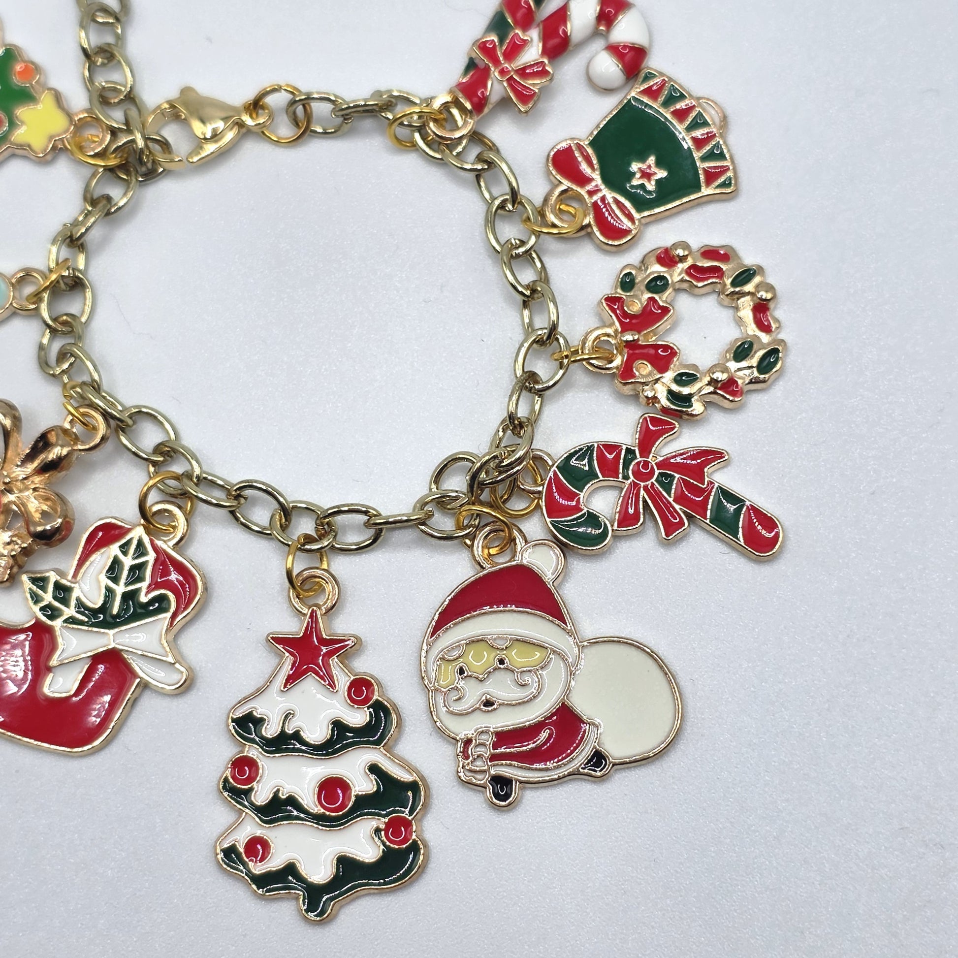 Gold charm bracelet with Christmas-themed charms on a white background