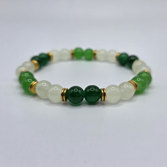Green beaded bracelet with gold accents on a light gray background